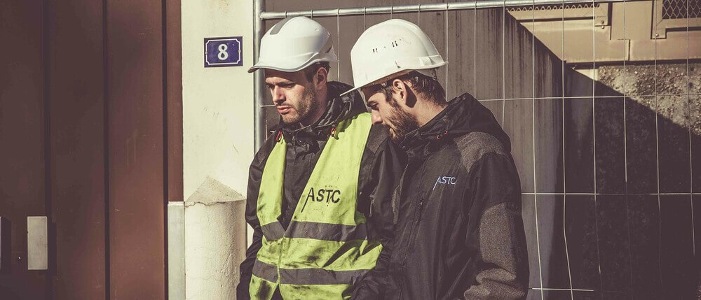 Employees wearing hardhats while surveying project