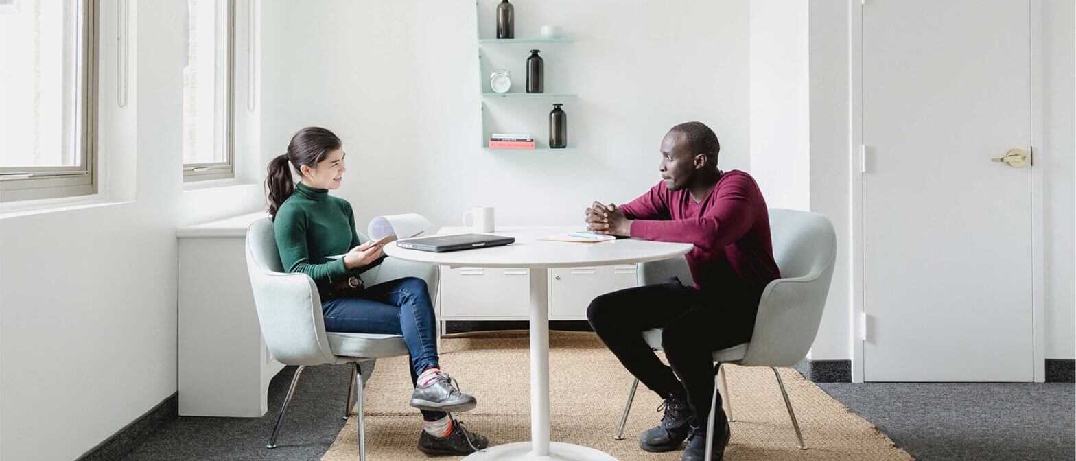Two people conversing at table