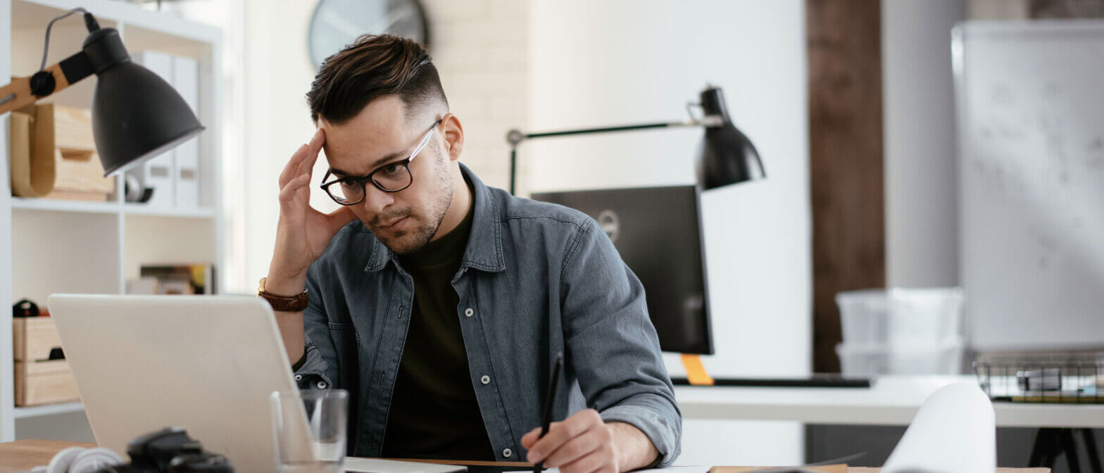 Employer client at a desk appearing to be challenged with a problem