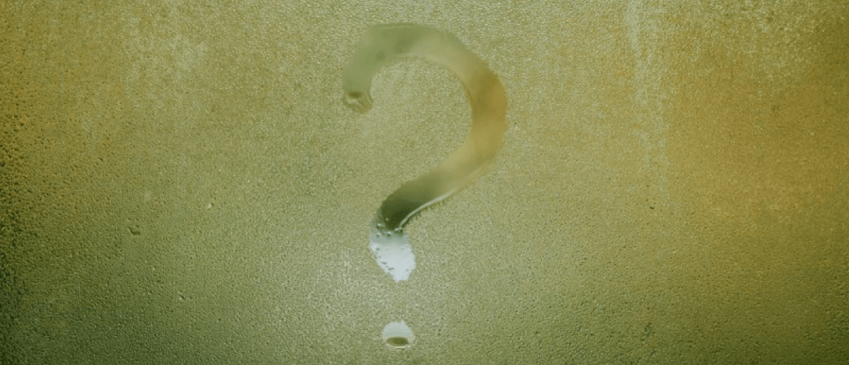 Question mark written on foggy glass